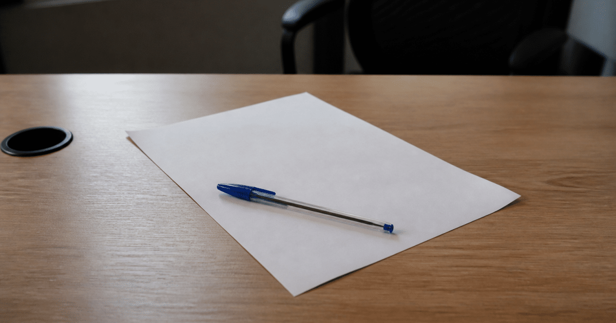 Document contractuel pose sur bureau avec stylo bleu