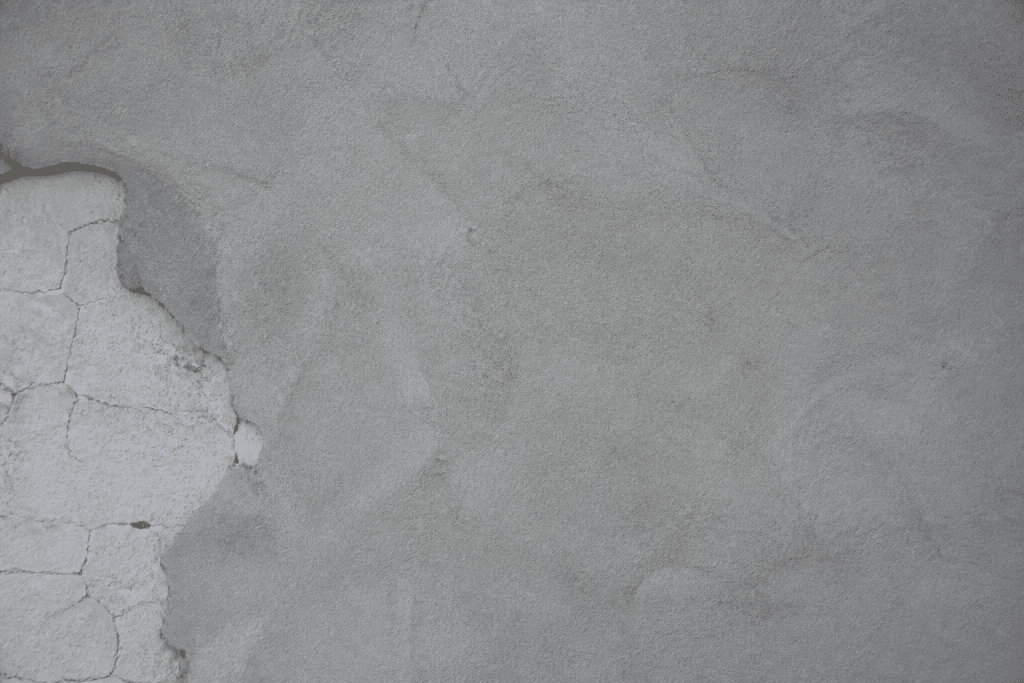 Mur blanc avec fissures recouvert d'enduit gris lisse