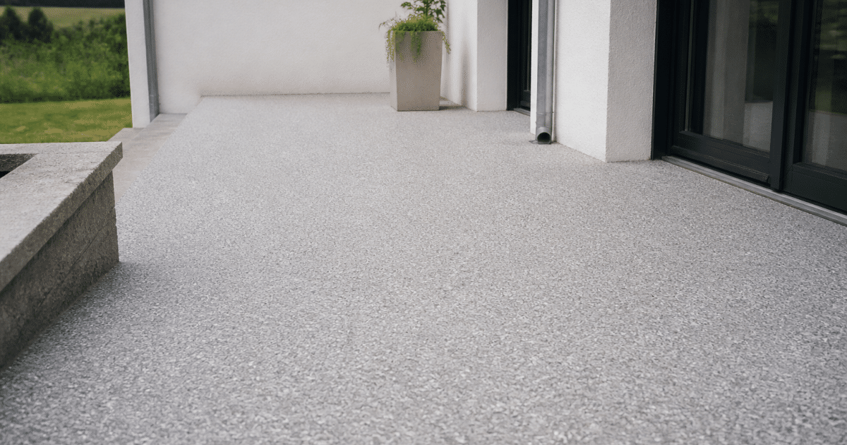 Terrasse recouverte de resine epoxy grise avec gravillons blancs etales