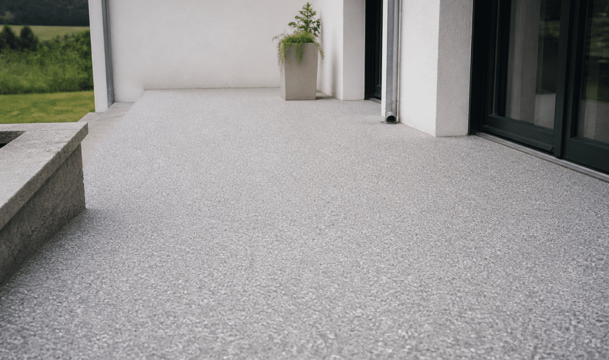 Terrasse recouverte de resine epoxy grise avec gravillons blancs etales