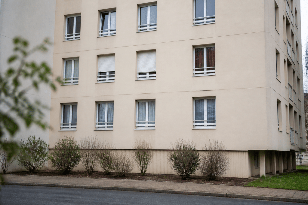 Immeuble résidentiel avec façade beige et fenêtres régulières