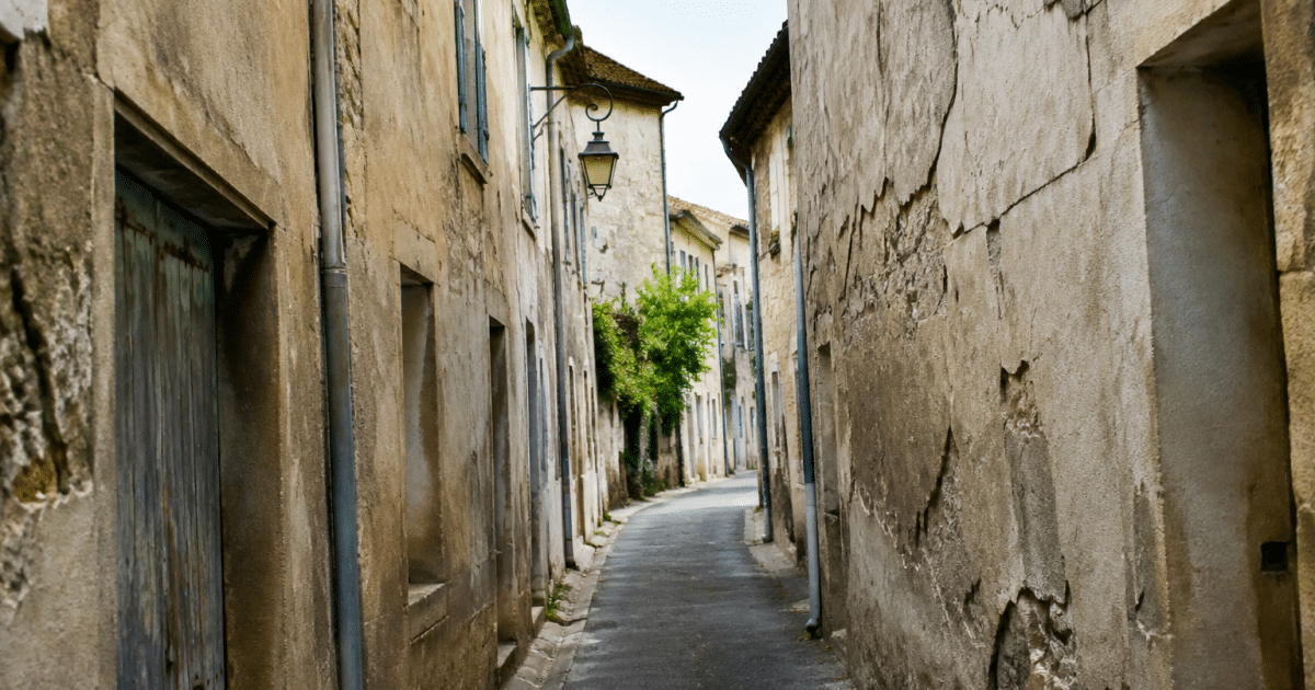 Rue etroite avec immeubles delabres et facade fissuree a Sorgues