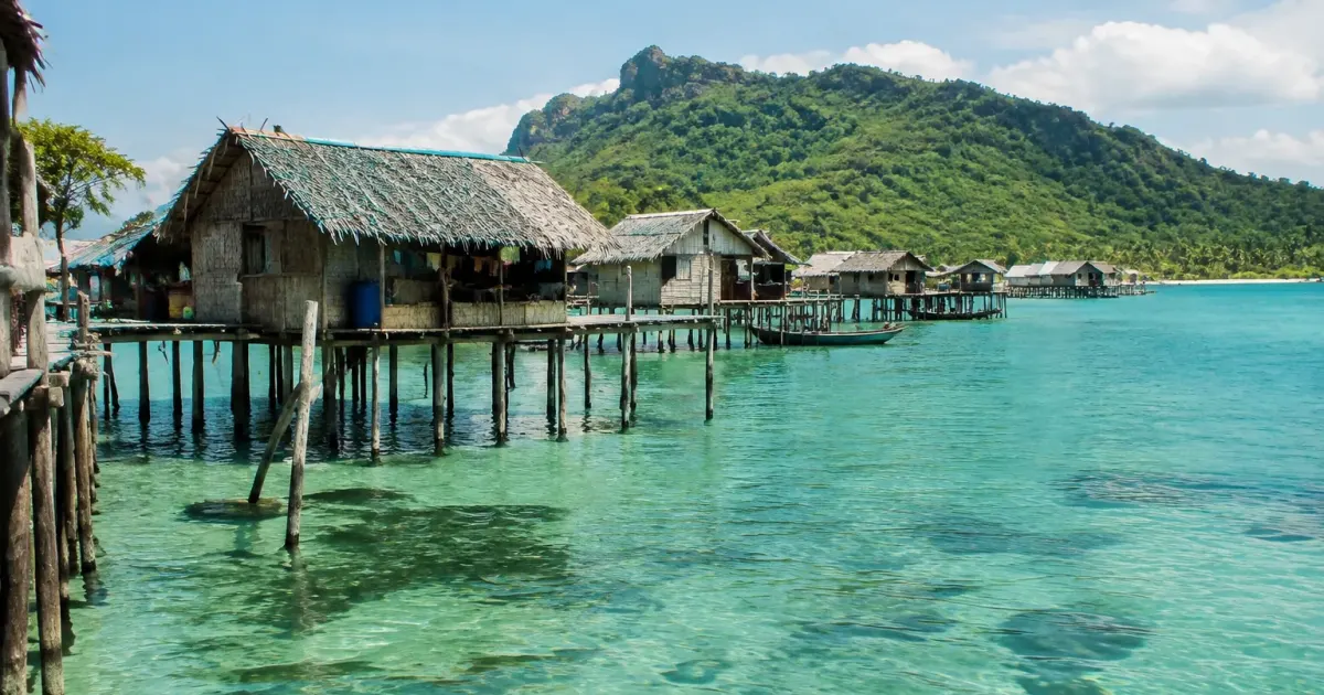 Village sur pilotis bordant un lagon turquoise